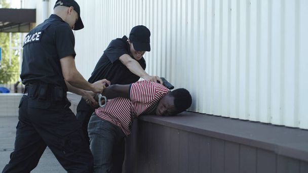 黒人を逮捕する警察官 - 写真・画像