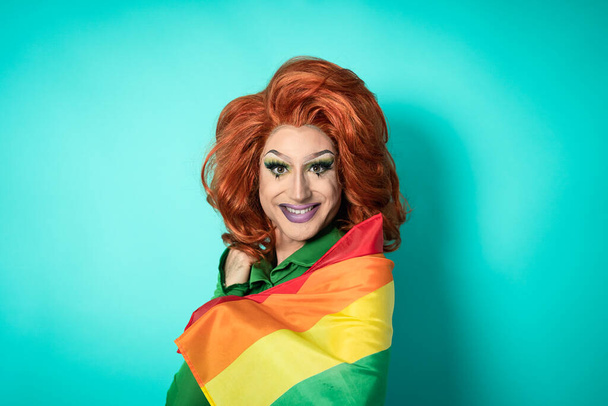 Feliz drag queen celebrando el orgullo gay sosteniendo la bandera del arco iris - concepto de movimiento social LGBTQ - Foto, imagen