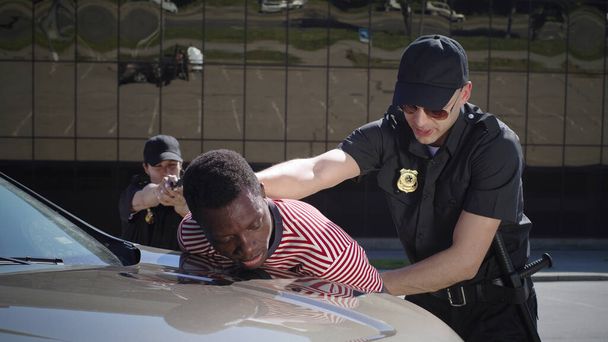 Police officers with gun arresting black driver - Photo, Image