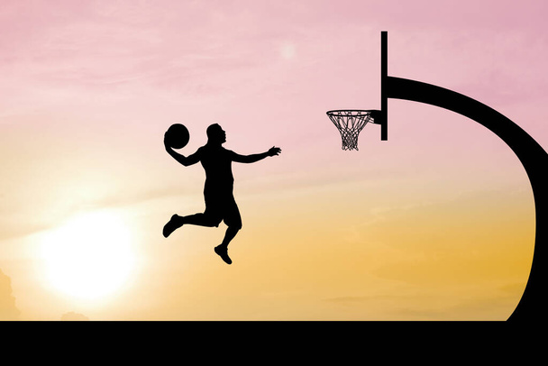 Basketball players jumping to dunk to score in the evening outdoor court. - Photo, Image