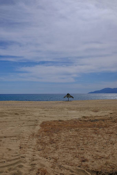Beach umbrella at the sandy beach of Mylopotas in Ios cyclades Greece  - Photo, Image