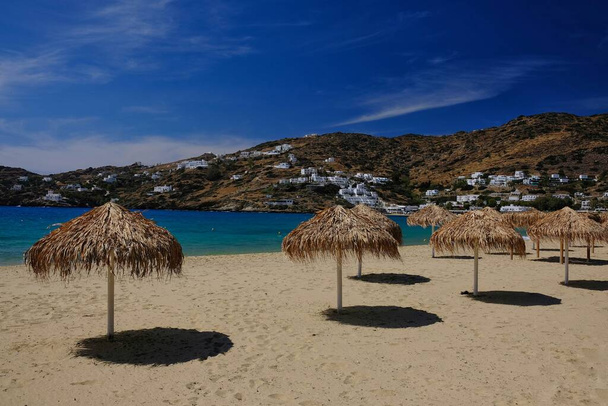 Sombrillas en la playa de arena de Mylopotas en Ios cyclades Grecia  - Foto, Imagen