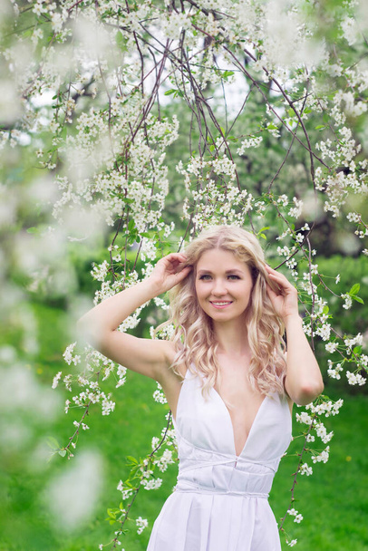 Дівчина, жінка, модель в білому сараї в саду з білими квітами. Літо
 - Фото, зображення