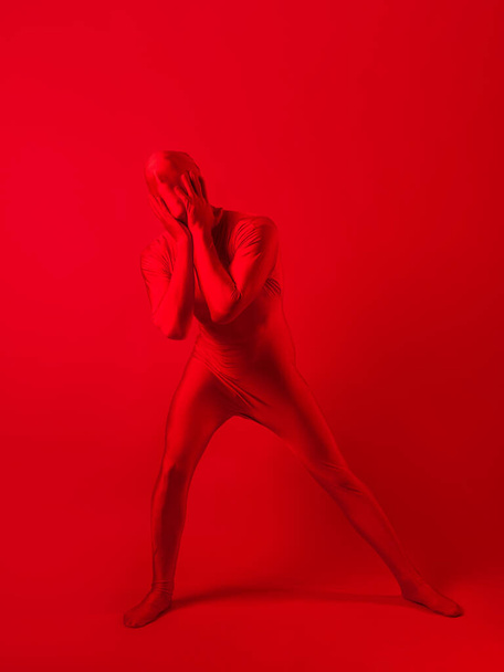 crazy red man on a red background. figure in a leotard covering the whole body - Fotó, kép