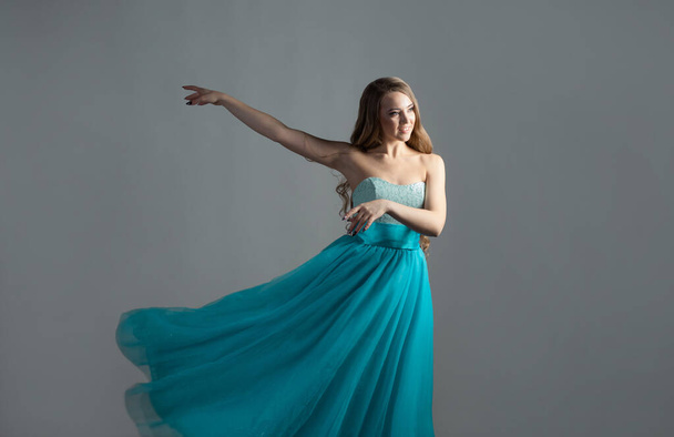 wonderful dancing princess in a lush blue dress, a young beautiful blonde - Фото, зображення
