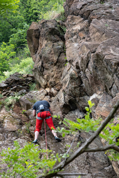 Lanzo-juni 2021 Jonge klimmers trainen op de rotsachtige muur bij de Stura. - Foto, afbeelding