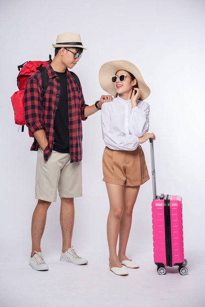 Hommes et femmes habillés de lunettes pour voyager avec des valises. - Photo, image