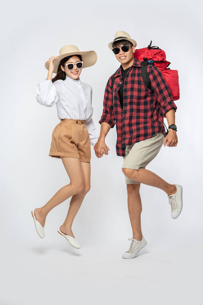 Men and women dressed up wearing glasses to travel with suitcases. - Фото, изображение
