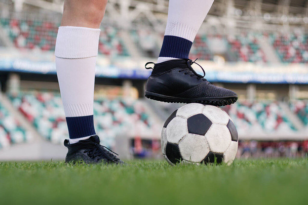 Nogi kobiecego piłkarza na piłce nożnej na stadionie, zbliżenie - Zdjęcie, obraz