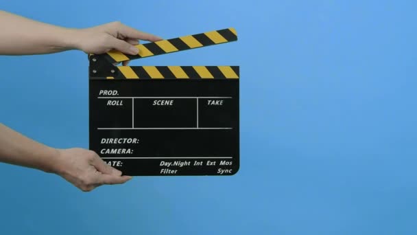 Film Slate or Movie Clapperboard with Blue Green screen background. Film crew man hold and hit film slate in the frame. Clapping film slate. Video production chroma key background. Film production.  - Filmati, video