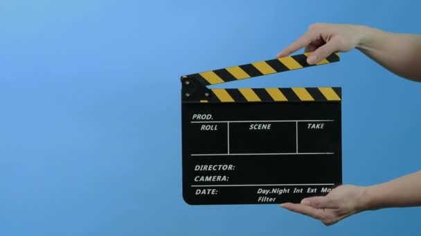 Film Slate or Movie Clapperboard with Blue Green screen background. Film crew man hold and hit film slate in the frame. Clapping film slate. Video production chroma key background. Film production.  - Footage, Video