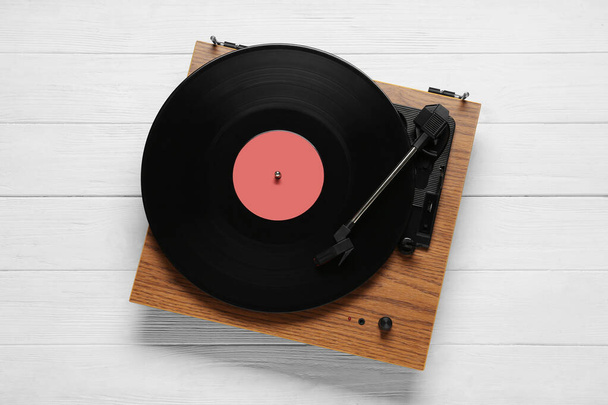 Turntable with vinyl record on white wooden background, top view - Photo, image