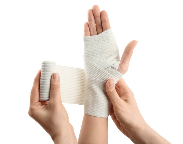 Woman applying bandage onto patient's hand on white background, closeup - Fotografie, Obrázek