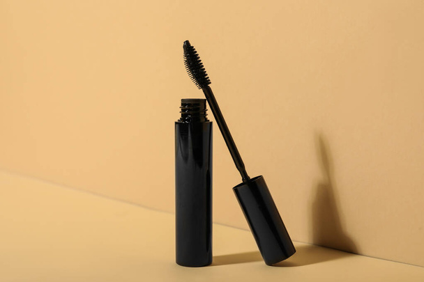 Mascara for eyelashes on beige background. Makeup product - Foto, imagen