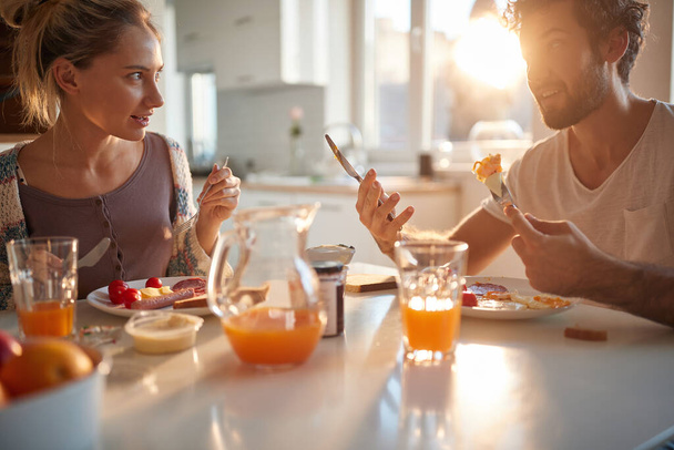 young caucasian adult couple having conversation at breakfast - Foto, afbeelding