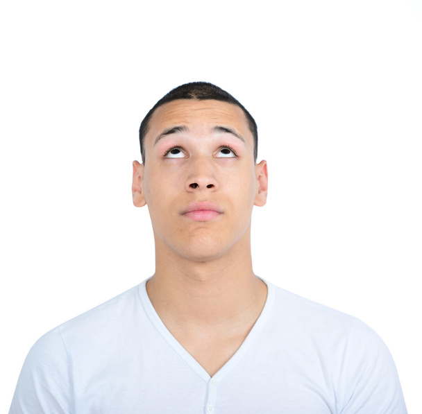 Portrait of young man looking up against white background - Foto, immagini