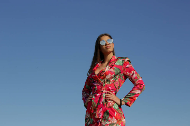 Outdoor portrait of gorgeous fashionable brunette girl against clear blue sky - Foto, afbeelding