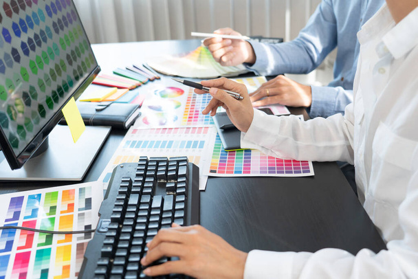 Projektant graficzny lub twórczej pracy razem kolorystyka za pomocą tabletu graficznego i rysik przy biurku z kolegą - Zdjęcie, obraz
