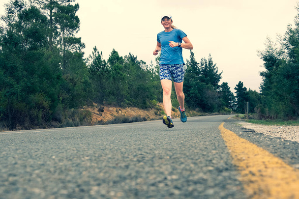forty something trail runner running along a dirt road - Photo, Image