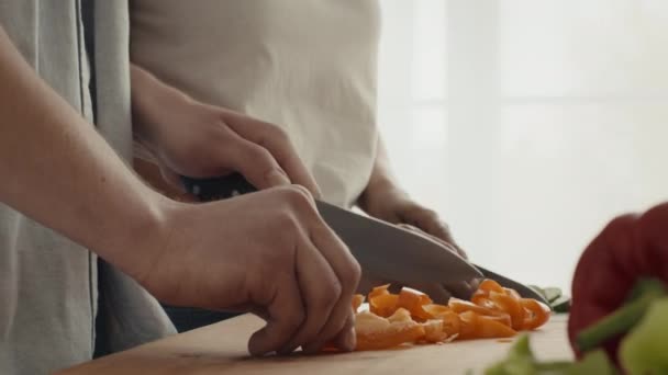 Tiro recortado de par de verduras de corte para la ensalada de cocina en interiores - Metraje, vídeo