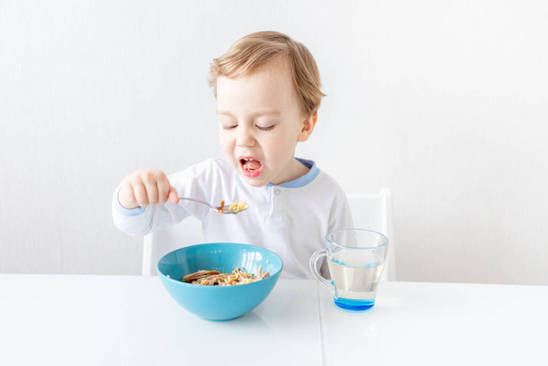 bambino non vuole mangiare se stesso con un cucchiaio a casa, il concetto di cibo e nutrizione per i bambini - Foto, immagini