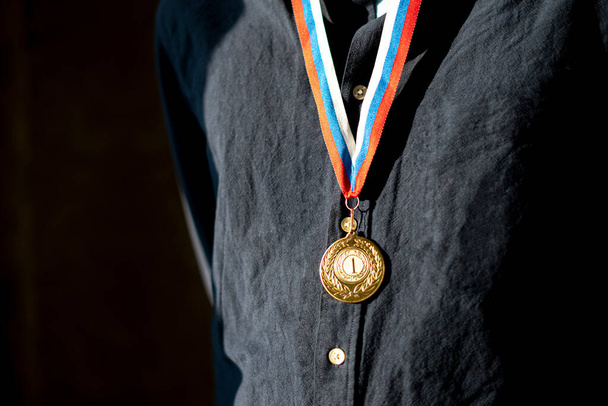 un uomo sportivo con una medaglia d'oro su un petto, campione leader - Foto, immagini
