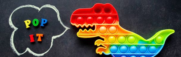 多色の文字と碑文を持つ黒の背景にそれ恐竜のおもちゃの虹色をポップバナー-スピーチバブルでそれをポップ. - 写真・画像