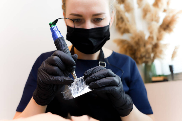 permanent makeup artist installs tattoo pigment in tattoo machine - Photo, Image