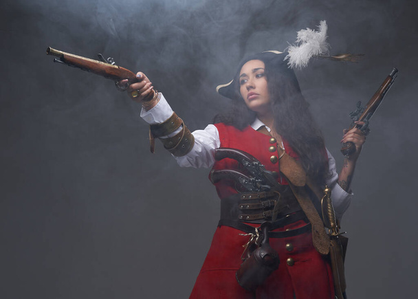 Καραιβική γυναίκα πειρατής ποζάρουν με όπλα στην ομίχλη - Φωτογραφία, εικόνα