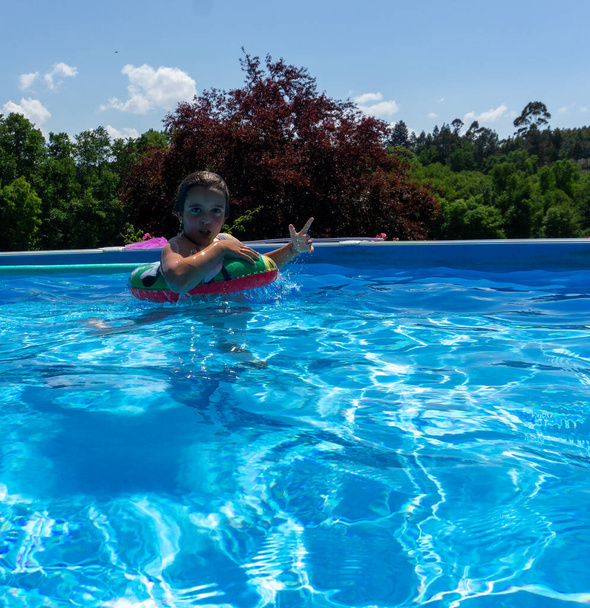 Девушка в воде бассейна на платформе, делает коммуникационные знаки - Фото, изображение