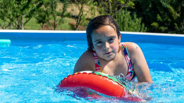 девушка купается в бассейне, скользящем в воде, прикрепленной к платформе - Фото, изображение