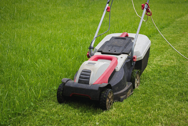 Electric Lawn Mower On Front Yard. Lawn Mower In Garden. - Photo, Image