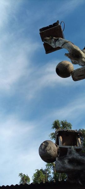 bird house on old wooden tree on cloudy blue sky background - Photo, Image
