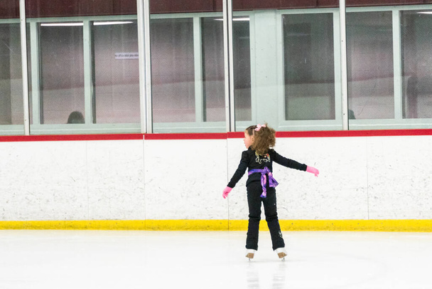小さな女の子練習フィギュアスケートムーブオンザ屋内アイスリンク. - 写真・画像