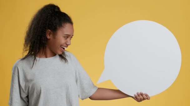 Opinione personale. Allegro afro-americano ragazza adolescente in possesso di bianco discorso bolla e annuendo testa in approvazione - Filmati, video