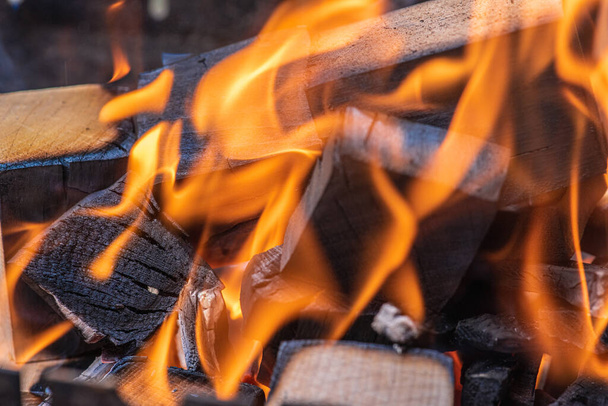 Ανάβοντας φωτιά, ένα ζεστό τζάκι με πολλά δέντρα έτοιμα για μπάρμπεκιου. Επιλεκτική εστίαση. Κλείσιμο προβολής - Φωτογραφία, εικόνα