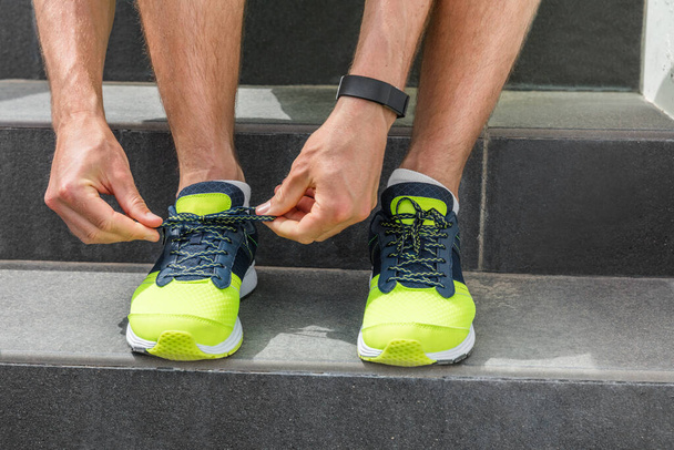 Sport man tying running shoes laces getting ready going to the gym workout wearing smartwatch for training cardio exercise on stairs. Acitve healthy lifestyle athlete, fitness motivation - Fotoğraf, Görsel