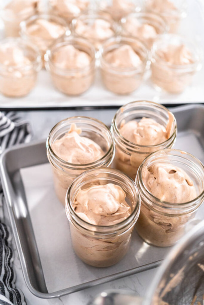 Scooping mixture into the small glass jars to make homemade chocolate ice cream. - Photo, Image