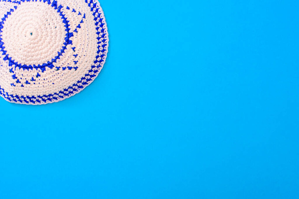 Kippah est un chapeau circulaire, avec le drapeau d'Israël, isolé sur un fond bleu. - Photo, image