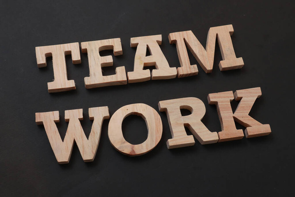 Teamwork, text words typography written with wooden letter on black background, life and business motivational inspirational concept - Fotografie, Obrázek