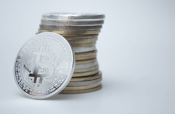 One silver bitcoin and stack of bitcoins over white background - Valokuva, kuva