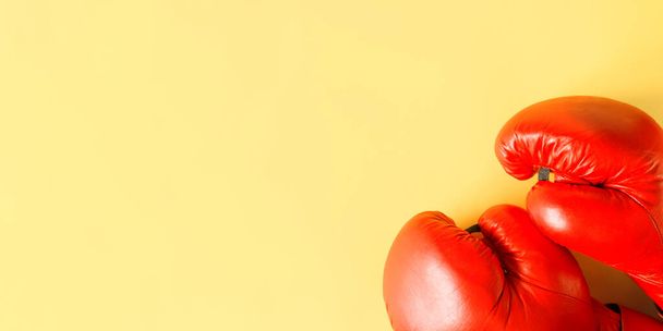 Red boxing gloves on a yellow background, top view. Sports banner, copy space - Photo, image