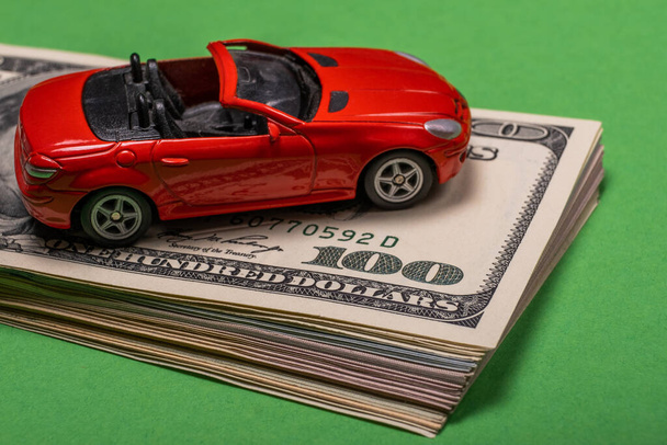 Een fragment van de Amerikaanse dollar is te zien op de tafel er staat een speelgoedauto op - Foto, afbeelding
