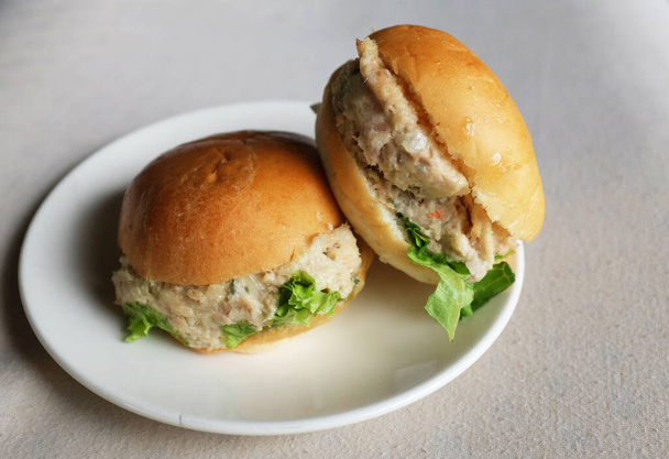 Mini-Thunfisch-Burger mit Mayonnaise auf weißem Teller. Leckeres Frühstück. - Foto, Bild