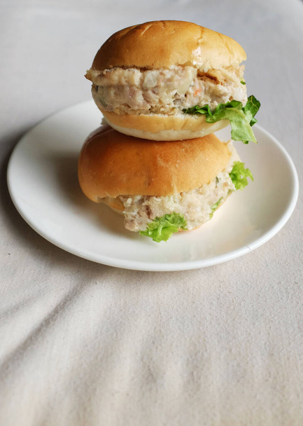 mini hambúrguer de atum fresco com maionese em um prato branco. Deliciosos breakfas. - Foto, Imagem