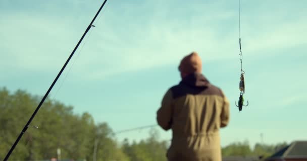Homme pêche sur jetée en bois près du lac - Séquence, vidéo