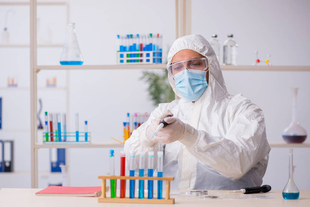 Junger Chemiker arbeitet während der Pandemie im Labor - Foto, Bild