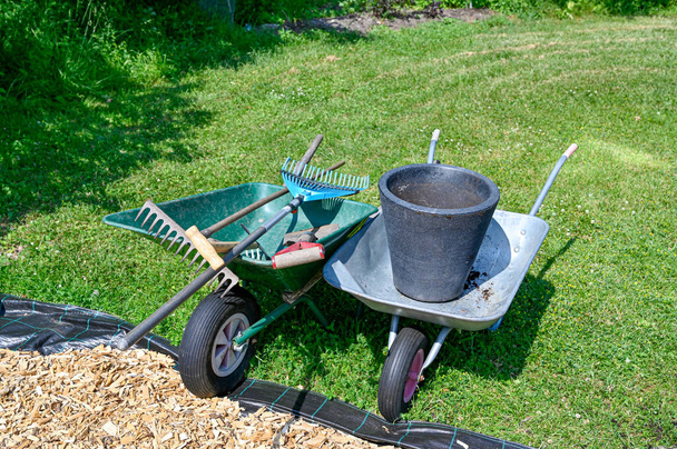 carretillas llenas de herramientas de jardín en el césped - Foto, imagen