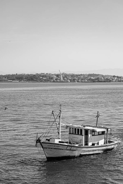 Fischerboot umgeben von Seevögeln in der Guanabara-Bucht, Rio de Janeiro, Brasilien. Die handwerkliche Fischerei wird autonom, von traditionellen Fischern oder in einer Familienwirtschaft ausgeübt..  - Foto, Bild