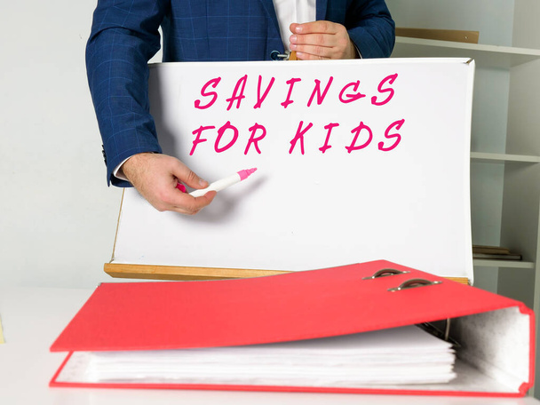 Business concept meaning SAVINGS FOR KIDS with sign on the piece of paper. - Fotografie, Obrázek